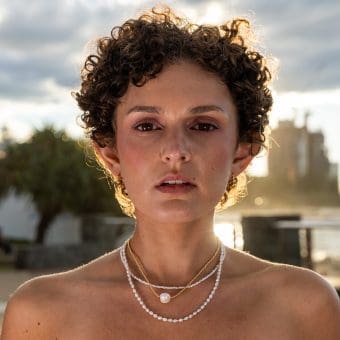 Woman wearing The Loop Store gold chain necklace & pearls, lifestyle shoot Gold Coast